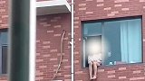 女子坐窗台上欲轻生，救援人员一脚将其“踢”回屋内