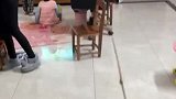 孩子们看电视都要凑得很近，女子只能拿着棍子驱赶，看的太近了容易近视