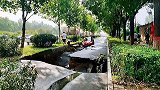 河北保定暴雨过后路面塌陷十余米长 一红色轿车陷入坑中无法动弹