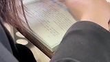 女大学生隔着课本玩手机，完美解决上课玩手机的问题