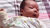 小宝宝今天满月了,一个人潇洒地躺在床上,两手挥来挥去的！
