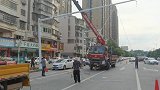 五个工人师傅配合默契，巧用物理中的杠杆原理，完成了灯柱的安装