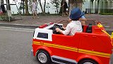 小朋友开着小汽车小吊车和挖土车玩耍