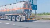 大车在高速路上推轿车前行，身后还跟了一辆油罐车