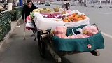 身残志坚男子每天拄着拐杖，推满满一车水果出门摆摊
