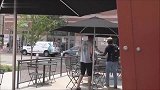 男子抽掉路人的凳子就跑，摄影师只好躲在桌子底下