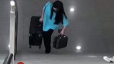 女孩独自提着行李箱上楼梯，路人上前接过箱子