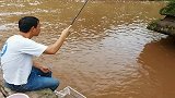 村里大河涨水了，老表拿着小鱼竿来坐钓，没想到还意外上了一条草