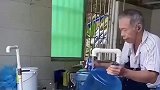大爷将水桶灌满水后，拿出塑料盖安装