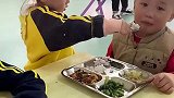 幼儿园小女孩喂小男孩吃饭，成熟得像个小老师