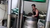 大哥用尽全力把东西放在机器上，没想到经过加工，变成了一个桶