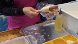小伙拿面团把火腿裹上，1份5块，食客边吃边点头：香！