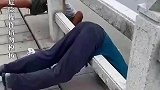 大叔集体在河边爬围栏上晨练