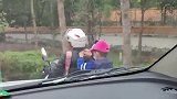 母亲接放学的孩子回家，孩子在后座偷偷扯母亲的衣服