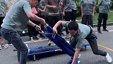 公司搞消防演习，小哥你们俩这是在搬运重伤员，下手要轻一点啊！
