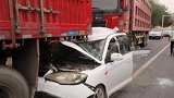 江苏一轿车等红灯被超载大货车追尾 受前后挤压严重变形