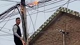 村里线缆起火，休假探亲的陈先生发现后，爬上梯子冲上去灭火