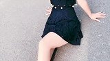 坐在马路上的美女展现长腿，在阳光下显得很白皙