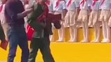 当抗战老兵经过会场，孩子们站起来敬礼