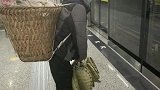 女生在轻轨内给提重物老人引路