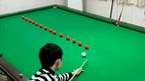 这孩子的台球技术太好了，每一杆都进一球，他到底是怎么做到的
