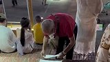 大爷将纸巾铺地板上，让大妈坐在上面