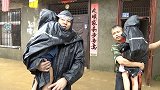 武汉江夏区暴雨40余户居民被困 救援人员将雨衣给孩子后抱出