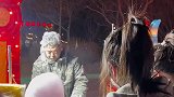 大爷在室外卖棉花糖，头和衣服被棉花糖黏住