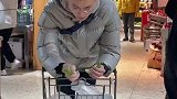 男子陪对象逛超市，边逛边择菜