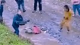 放学后，小学生往泥坑摔书包玩