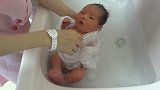 护士给新生宝宝洗澡，宝宝在水里的反应好萌啊