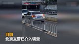 【北京】逆行轿车被车流顶着倒退数百米 网友：哪里来的回哪里
