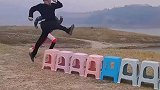 年轻功练就，男子空中两步跨越个凳子