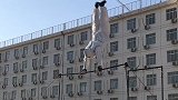 最特别的杠上“大风车” 武警老班长穿着防护服玩单杠
