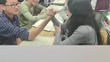 老师和学生掰手腕，学生们在一旁加油助威
