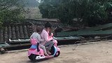 两个宝宝真会玩，在自家的院子里骑着小摩托，自由自在的样子好萌