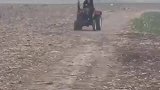 女子驾驶拖拉机，在荒地上肆意横行