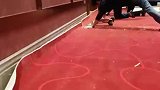 工人跪地用膝盖当锤子铺地毯