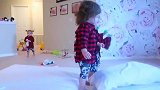 两个小宝宝在床上，一个跳来跳去，另一个喜欢玩枕头