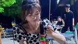 女子将瓶盖戳破后，不断敲击瓶身啤酒喷出