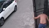 铁门突然松动倾倒，险些砸到路过的男子
