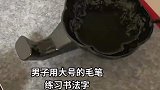 男子用大号的毛笔练习书法，没有技巧全是感情