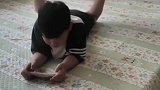男孩边玩手机边转枕头，手脚各有一套独立系统