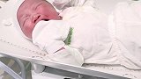 刚从妈妈肚子里出来的小宝宝，穿上新衣服后露出可爱的笑脸！