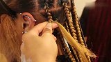 女子头发蓬松又卷，编成很多辫子，好看又显个性