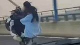 男孩载着女孩大桥上飙车,不时翘头炫技