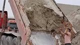 车后斗的沙土凝结，男子用铁锹一点点铲下