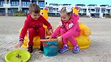 萌娃小可爱们在沙滩玩耍，挖到了好多有趣的玩具！