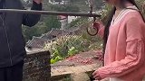 女生单手抓着铁钩，双脚悬空称重