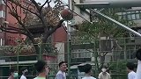 篮球卡在篮筐上了，看小伙的动作非常熟练